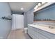 Well-lit bathroom features a double sink vanity, large mirror, and shower with a white curtain at 6664 Kara Ln, Brownsburg, IN 46112