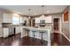 Bright kitchen with a center island, white cabinets, stainless steel appliances and hardwood floors at 6664 Kara Ln, Brownsburg, IN 46112
