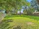 Spacious backyard with lush green grass and mature trees, perfect for outdoor activities at 6739 Westdrum Rd, Indianapolis, IN 46241