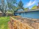 Back of house with a wood deck and large green backyard with mature trees at 6739 Westdrum Rd, Indianapolis, IN 46241