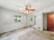 Bedroom with window, closet, and visible signs of wear and tear on walls and floor at 6739 Westdrum Rd, Indianapolis, IN 46241