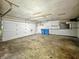Empty garage featuring a white garage door and blue recycling bins at 6739 Westdrum Rd, Indianapolis, IN 46241