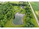 Aerial view of a serene pond surrounded by lush greenery and the backyard pool at 750 N 500 W, Lebanon, IN 46052