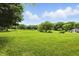 Expansive backyard featuring lush green grass, mature trees, and a tranquil pond in the distance at 750 N 500 W, Lebanon, IN 46052