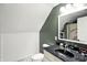 A well-lit bathroom features wainscotting, a black granite countertop, and a sloped ceiling at 750 N 500 W, Lebanon, IN 46052