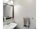 Well-lit powder room featuring a pedestal sink, black framed mirror, and sleek towel bar, creating a simple yet stylish space at 750 N 500 W, Lebanon, IN 46052