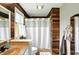 Cozy bathroom featuring wood paneling and a shower with a white shower curtain for a rustic yet modern feel at 750 N 500 W, Lebanon, IN 46052