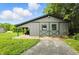 The grey and green trim shed has 2 square windows and a covered area at 750 N 500 W, Lebanon, IN 46052