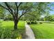 Scenic pathway winding through a green lawn with trees and blooming flowers along the way at 750 N 500 W, Lebanon, IN 46052