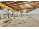Unfinished basement with concrete floor, utility hookups, and exposed wooden ceiling joists offers potential for customization at 7604 Brownstone Ct, Greenfield, IN 46140