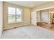 Well-lit bedroom with soft carpet, neutral walls, and a window showing the neighborhood at 7604 Brownstone Ct, Greenfield, IN 46140