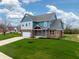 Attractive two-story home with brick accents, blue siding, and a well-maintained lawn at 7604 Brownstone Ct, Greenfield, IN 46140