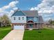 Charming two-story home featuring a brick facade, light blue accents, and a well-manicured lawn at 7604 Brownstone Ct, Greenfield, IN 46140