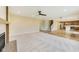 Open-concept living room with a fireplace, ceiling fan and hardwood floors flowing into the kitchen at 7604 Brownstone Ct, Greenfield, IN 46140