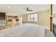Open-concept living space with a fireplace, access to the kitchen, and ample natural light at 7604 Brownstone Ct, Greenfield, IN 46140