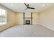 Cozy living room with a fireplace, ceiling fan, and a large window providing natural light at 7604 Brownstone Ct, Greenfield, IN 46140