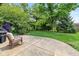 Backyard featuring a concrete patio with a rocking chair overlooking a lush lawn and mature trees at 767 Harvest Ridge Dr, Avon, IN 46123