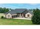 Attractive brick home with a three car garage, lush greenery, and a well-maintained lawn, exemplifying suburban charm at 7702 N County Road 300 W, Lizton, IN 46149