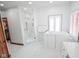 Bright bathroom featuring a walk-in shower, tub, and marble-pattern tile flooring at 7845 Centerstone Ct, Indianapolis, IN 46259