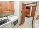Laundry room area features a modern washer and dryer next to a wooden storage cabinet at 7845 Centerstone Ct, Indianapolis, IN 46259