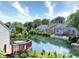 View of a serene waterfront backyard setting, complete with lush greenery and multiple houses at 7846 Park North Cir, Indianapolis, IN 46260