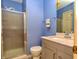 Traditional bathroom featuring a glass shower, toilet, vanity with a marble top, and blue painted walls at 7846 Park North Cir, Indianapolis, IN 46260