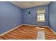 Bedroom featuring laminate wood flooring, blue walls, and a window with natural light at 7846 Park North Cir, Indianapolis, IN 46260