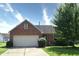 Charming one-story brick home featuring an attached garage and well-maintained landscaping at 7846 Park North Cir, Indianapolis, IN 46260
