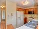 Well-lit kitchen with wooden cabinetry, white appliances, and a stainless steel sink at 7846 Park North Cir, Indianapolis, IN 46260