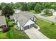 An aerial view shows a well-maintained white home with gray trim, nestled in a leafy suburban neighborhood at 7914 Trotwood Cir, Indianapolis, IN 46256