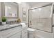 Bright bathroom featuring a granite vanity top, a white cabinet and a sliding glass door shower at 7914 Trotwood Cir, Indianapolis, IN 46256