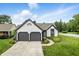 Beautiful home featuring an attached two-car garage, manicured lawn, and attractive landscaping at 7914 Trotwood Cir, Indianapolis, IN 46256