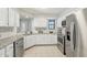 Modern kitchen features stainless steel appliances, white cabinets, and granite countertops at 7914 Trotwood Cir, Indianapolis, IN 46256