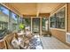 Cozy sunroom with many windows, tile floor, wicker chairs, and a blue and white area rug at 7914 Trotwood Cir, Indianapolis, IN 46256