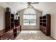 Inviting bedroom with a large arched window, built-in wooden cabinets, and ceiling fan at 7919 Cool Hollow Pl, Indianapolis, IN 46237