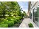 Expansive lawn with mature trees and green bushes surrounding a well-maintained home and walkway at 7919 Cool Hollow Pl, Indianapolis, IN 46237