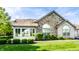 Charming single-story home featuring a stone accent wall, manicured lawn and verdant green bushes at 7919 Cool Hollow Pl, Indianapolis, IN 46237