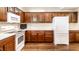 This updated kitchen includes wood floors, ample cabinet space, and white appliances at 7919 Cool Hollow Pl, Indianapolis, IN 46237