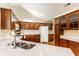 Well-lit kitchen boasts granite counters, stainless sink, and wood cabinets at 7919 Cool Hollow Pl, Indianapolis, IN 46237
