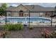 Community pool with lounge chairs, surrounded by a decorative fence and landscaping at 7919 Cool Hollow Pl, Indianapolis, IN 46237