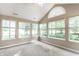 Bright sunroom bathed in natural light with large arched window, ceiling fan and plush carpeting at 7919 Cool Hollow Pl, Indianapolis, IN 46237