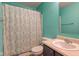 Colorful bathroom featuring turquoise walls, decorative shower curtain and vanity at 9593 W Constellation Dr, Pendleton, IN 46064