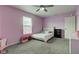 Bright bedroom with lavender walls, carpeted floors, and a comfortable bed at 9593 W Constellation Dr, Pendleton, IN 46064