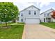 Charming two-story home featuring light gray siding, a spacious two-car garage, and a well-manicured front yard with lush green grass at 9593 W Constellation Dr, Pendleton, IN 46064