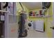 Well-lit laundry room featuring a washer, dryer, water heater, and ample storage space at 9593 W Constellation Dr, Pendleton, IN 46064