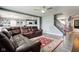 Open living room featuring hardwood floors, a ceiling fan, a comfortable sectional sofa, and an open concept to the kitchen at 9593 W Constellation Dr, Pendleton, IN 46064
