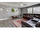 Comfortable living room featuring hardwood flooring, a brown leather sectional sofa, and a wall-mounted TV at 9593 W Constellation Dr, Pendleton, IN 46064
