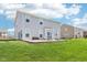 Large backyard with a well-maintained lawn and patio seating area to enjoy outdoor living at 9916 Gallop Ln, Fishers, IN 46040