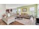 Spacious living room with a sectional sofa, natural light, and seamless flow to the kitchen area at 9916 Gallop Ln, Fishers, IN 46040