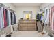 Walk-in closet featuring custom shelving and storage plus a vanity with mirror at 9916 Gallop Ln, Fishers, IN 46040